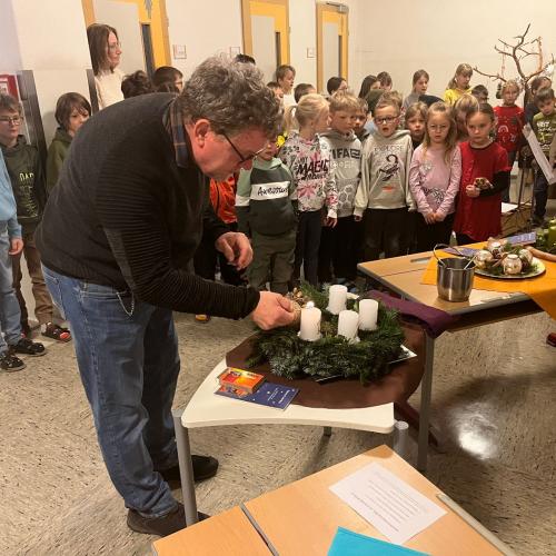 Schulleiter zündet die  erste Kerze an