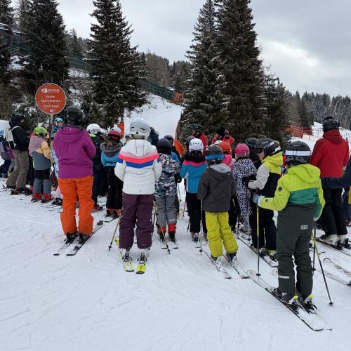 Kinder von hinten beim Anstellen auf der Schipiste