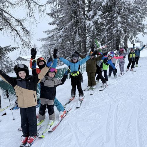 Kinder beim Schifahren in einer Reihe 