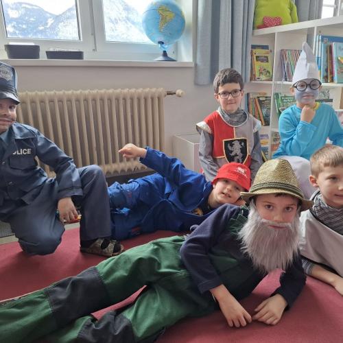 Verkleidete Kinder liegen und sitzen am Boden