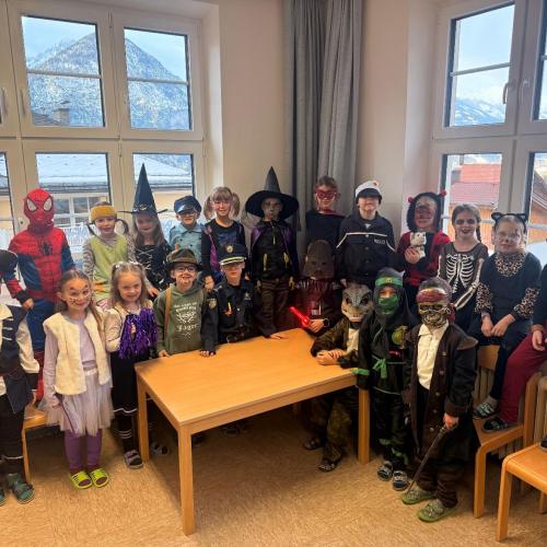 Verkleideter Kinder stehen, sitzen hinter einem Tisch