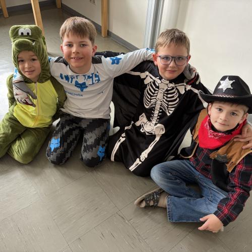 Vier verkleidete Kinder sitzen zusammen am Boden