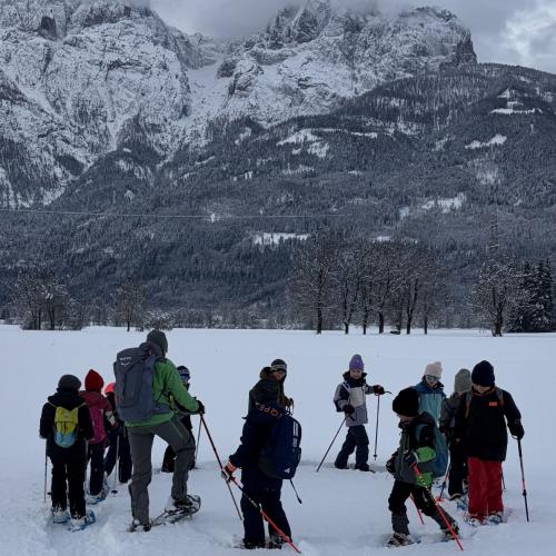 KInder und Rangerin gehen mit den Schneeschuhen im Kreis