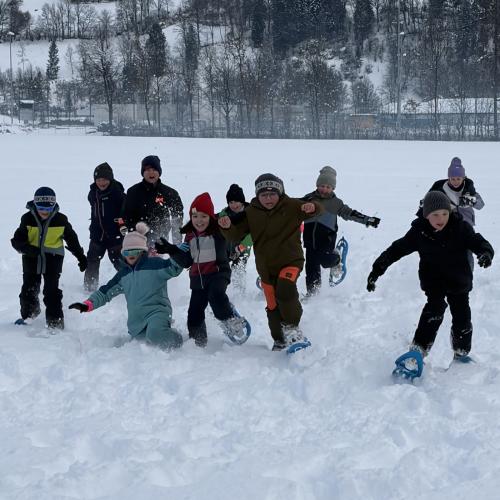 Kinder laufen mit den Schneeschuhen