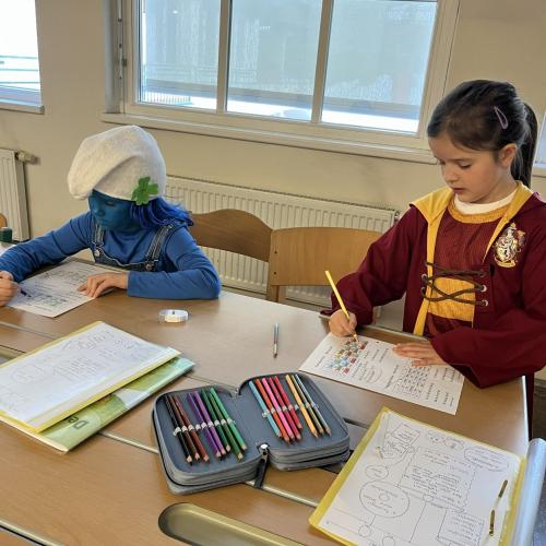 Verkleidete Kinder schreiben in den Heften