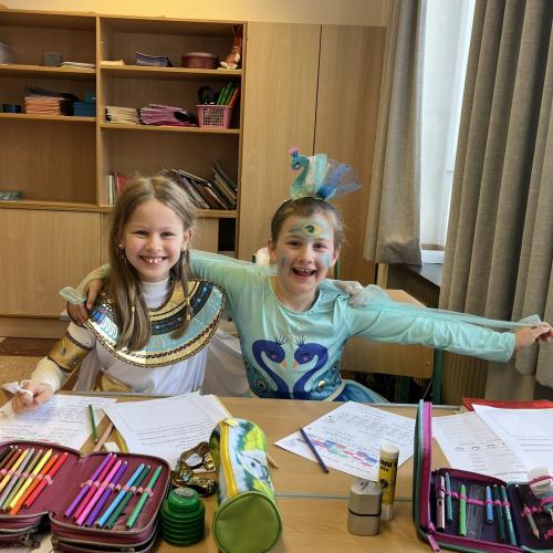 Zwei verkleidete Kinder sitzen am Tisch