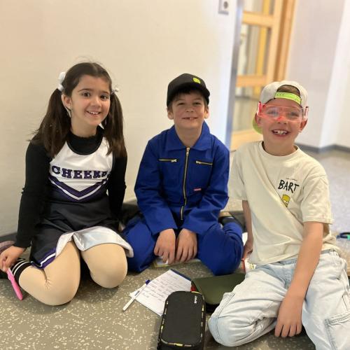 Drei verkleidete Kinder sitzen am Boden