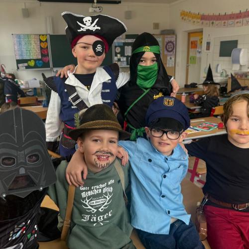 Verkleidete Kinder sitzen und stehen zusammen