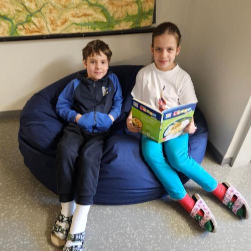 2 Kinder sitzen im Lesesack und lesen