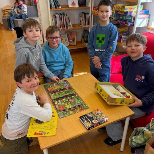 Kinder sitzen am Tisch und spielen gemeinsam