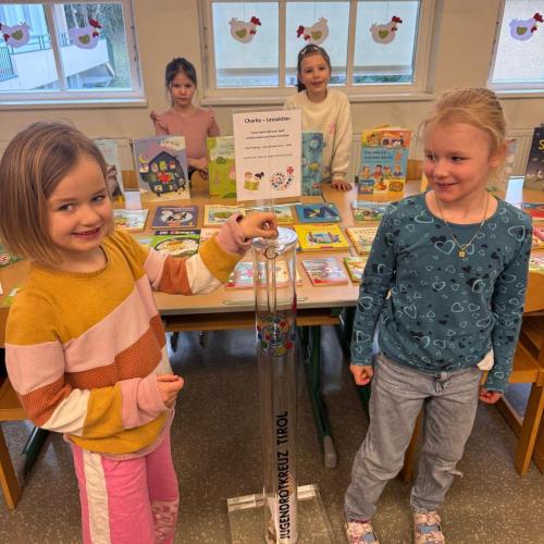 2 Kinder zeigen die Geldsammelsäule vor