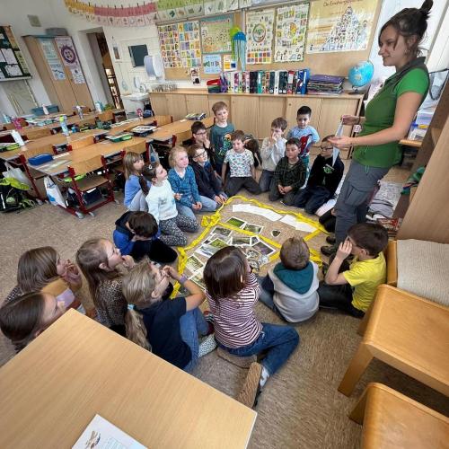Kinder sitzen am Boden und schauen Fotos an