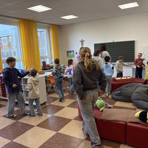 Kinder gehen in Klasse herum und suchen Hinweis