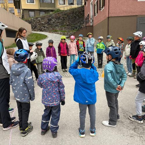 Kinder stehen im Kreis und hören Trainerin zu