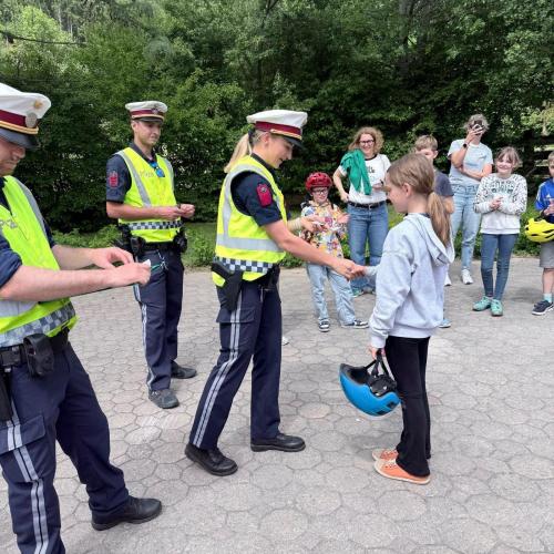 Polizistin überreicht Mädchen den Radausweis