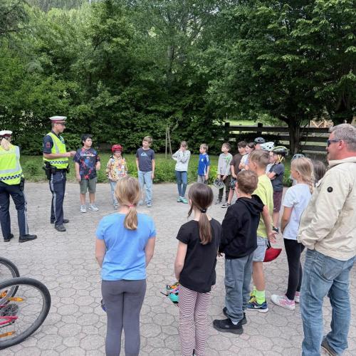 KInder stehen im Halbkreis um Polizist:innen herum 