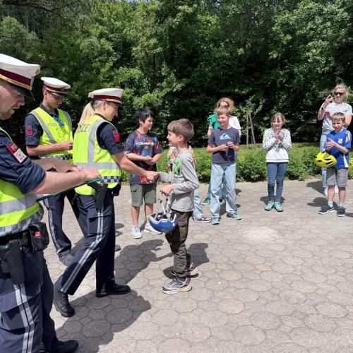 Polizistin überreicht Jungen den Radausweis