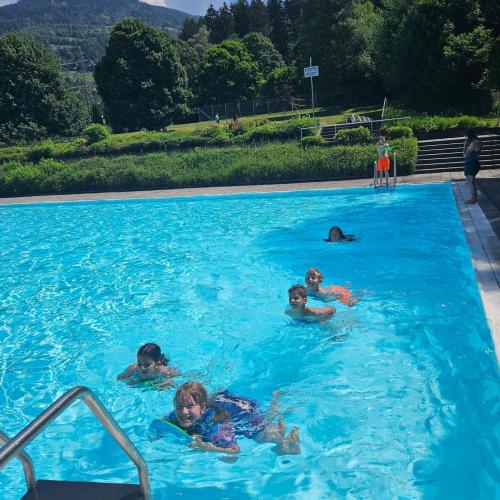 Kinder schwimmen hintereinander in einer Reihe