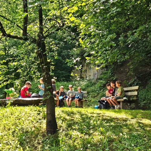 Kinder sitzen auf Rastbänken