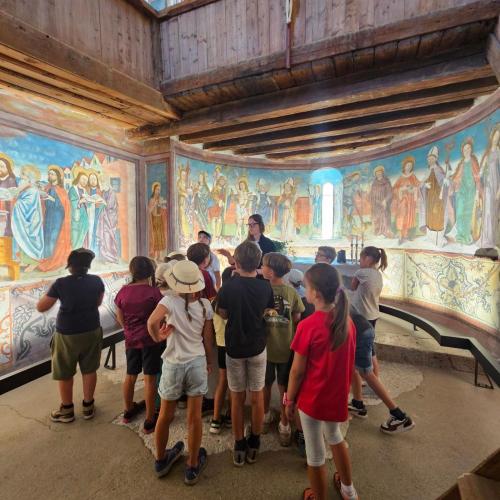 KInder und Lehrpersonen betrachten Wandmalereien in der Schlosskapelle