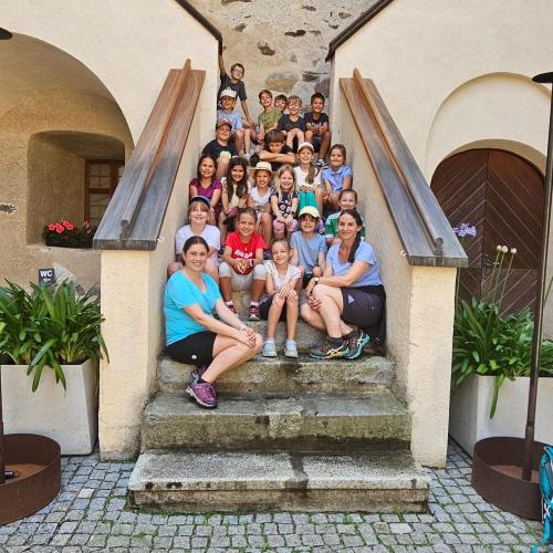 KInder und Lehrpersonen sitzen auf den Stufen
