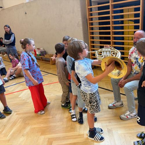 Kinder probieren das Spielen auf dem Horn