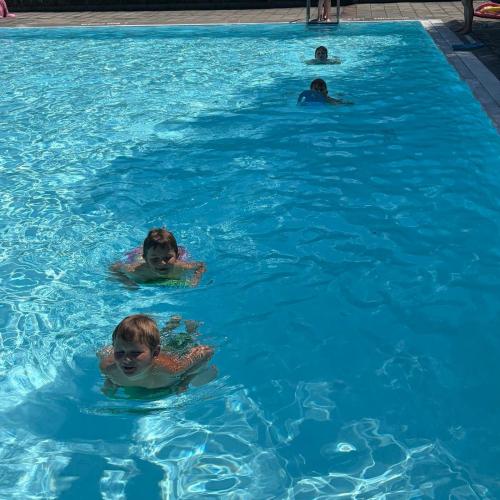 Kinder schwimmen mit Schwimmbrett in einer Reihe