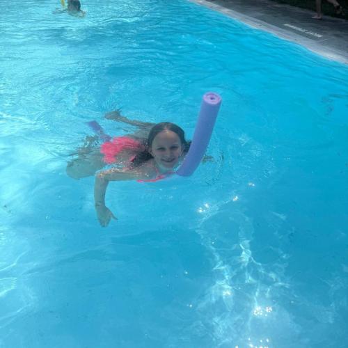 Mädchen schwimmt mit Schwimmnudel