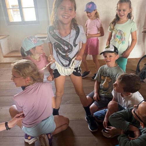 Kinder sitzen und stehen in Museumsraum