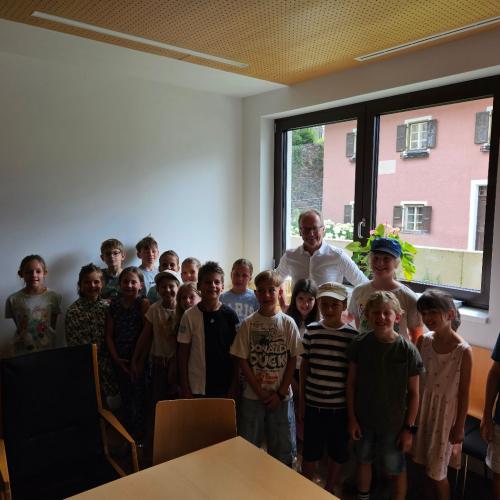Bürgermeister und Kinder im Gemeindeamt