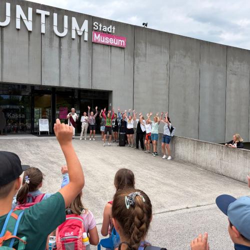 Museumsleiter, Eltern und Kinder stehen vor dem Museum
