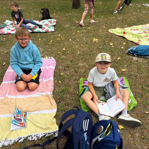 Buben sitzen auf Decken und lesen