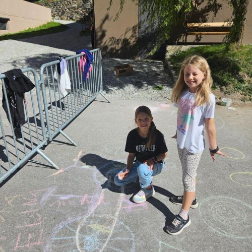 Kinder bemalen Parkplatz mit Straßenkreiden