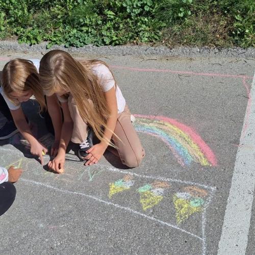 KInder bemalen Parkplatz mit Straßenkreiden