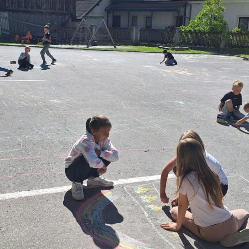 KInder bemalen Parkplatz mit Straßenkreiden