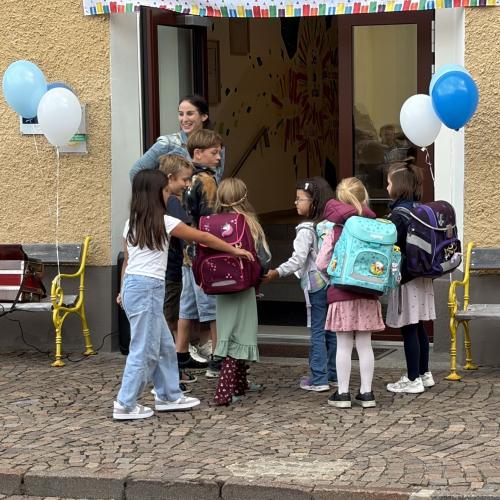 Schüler:innen der 4. Klasse begleiten Erstklassler ins Schulhaus