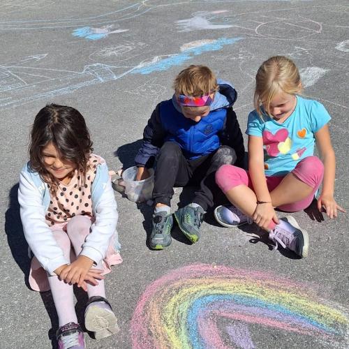 KInder bemalen Parkplatz mit Straßenkreiden