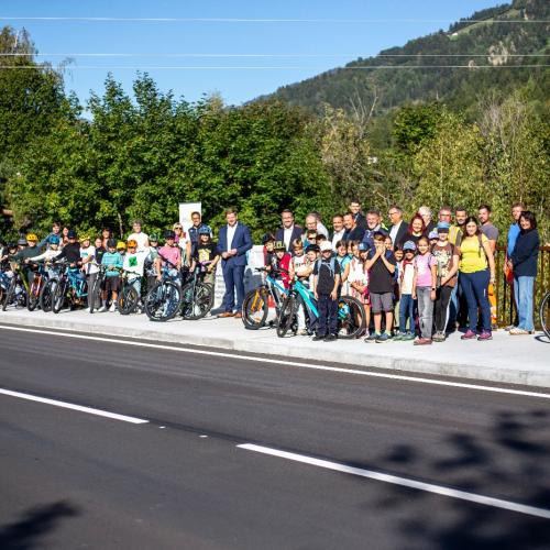 Festgäste und Schüler:innen stehen am Fahrradstreifen