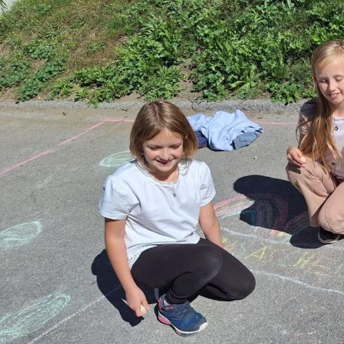 KInder bemalen Parkplatz mit Straßenkreiden