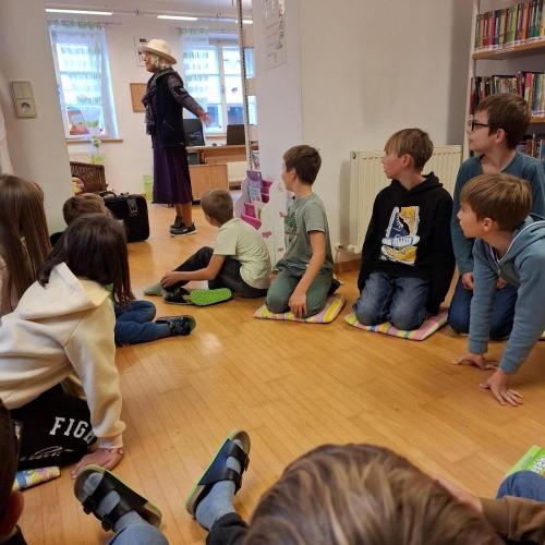 Kinder sitzen am Boden, Frau Lizzi kommt herein