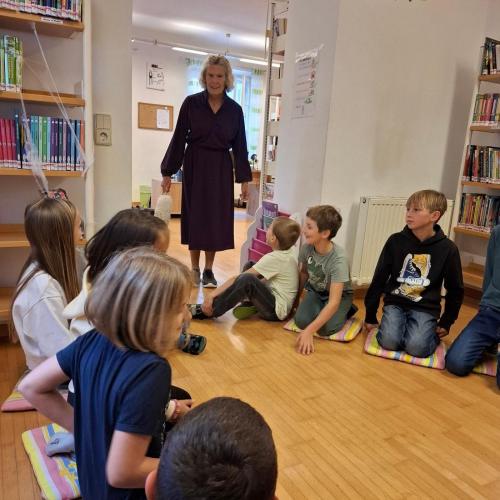 Kinder sitzen am Boden, Frau Lizzi stellt sich vor