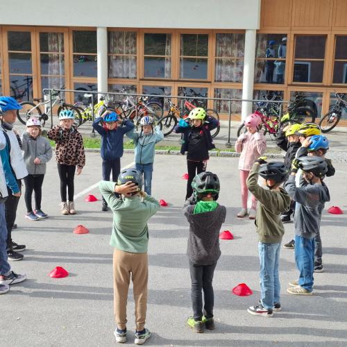 Kinder stehen im Kreis und passen die Helme an