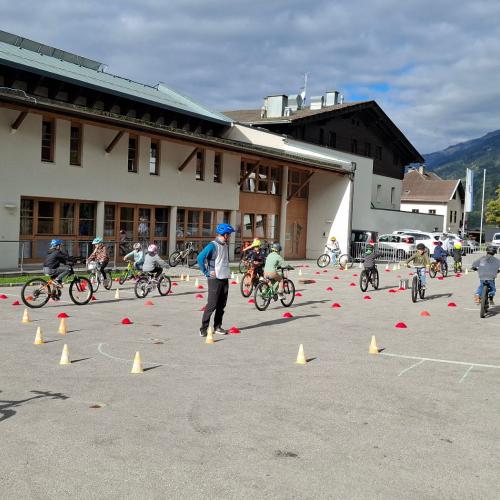 Kinder fahren mit den Rädern durch Parcour