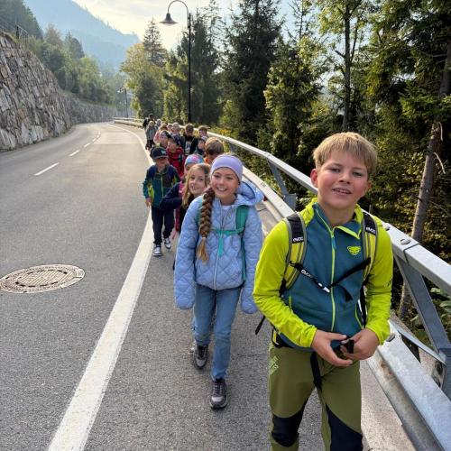 Kinder gehen hintereinander auf Gehweg