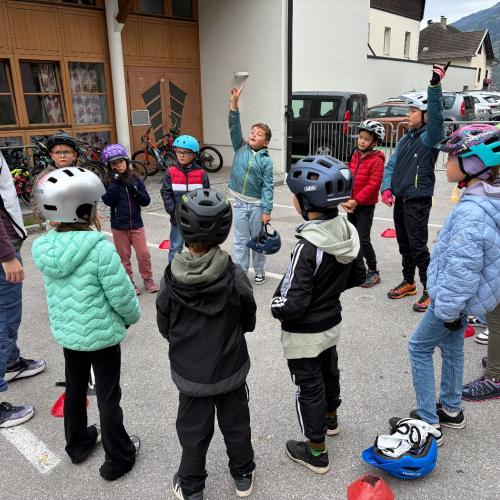 Kinder stehen im Kreis und hören der Fahrlehrerin zu