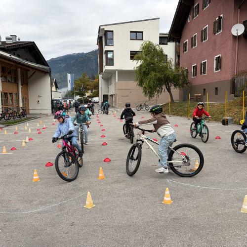 KInder fahren mit den Rädern durch Parcour