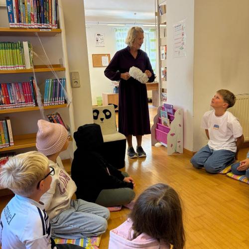 KInder sitzen am Boden, Frau Lizzi stellt sich vor