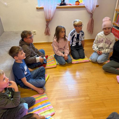 KInder sitzen am Boden 