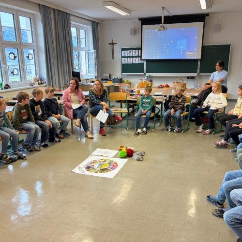 Kinder sitzen im Kreis und hören den Bäuerinnen zu
