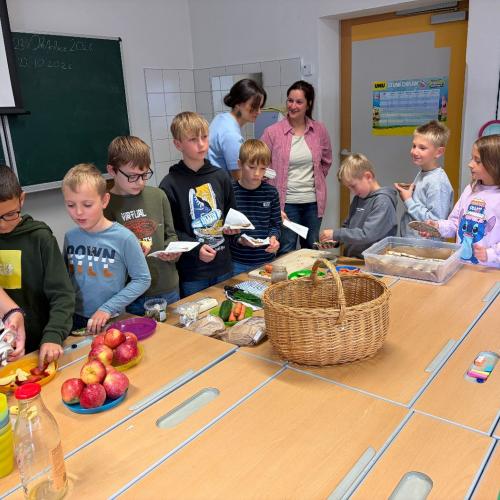 Kinder beim Tisch mit Jause, Kinder belegen Brote 